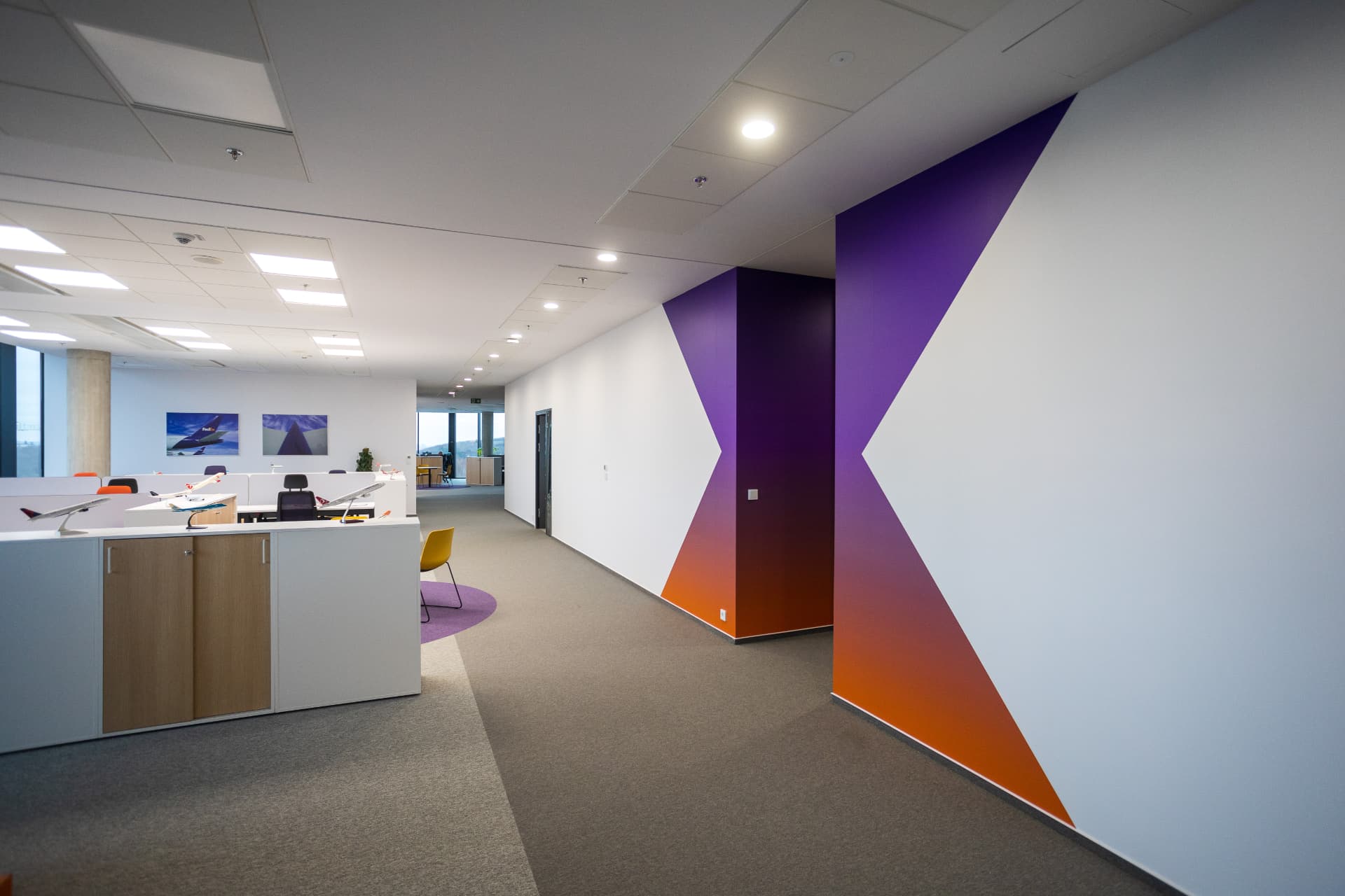 Chodba kanceláří FedEx s fialovo-oranžovým brandem na zdech
